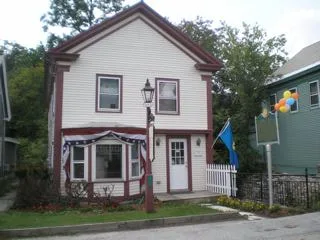 Image of the Mill Brook House that was lost in Irene in 2011. White, two story house, with red border.